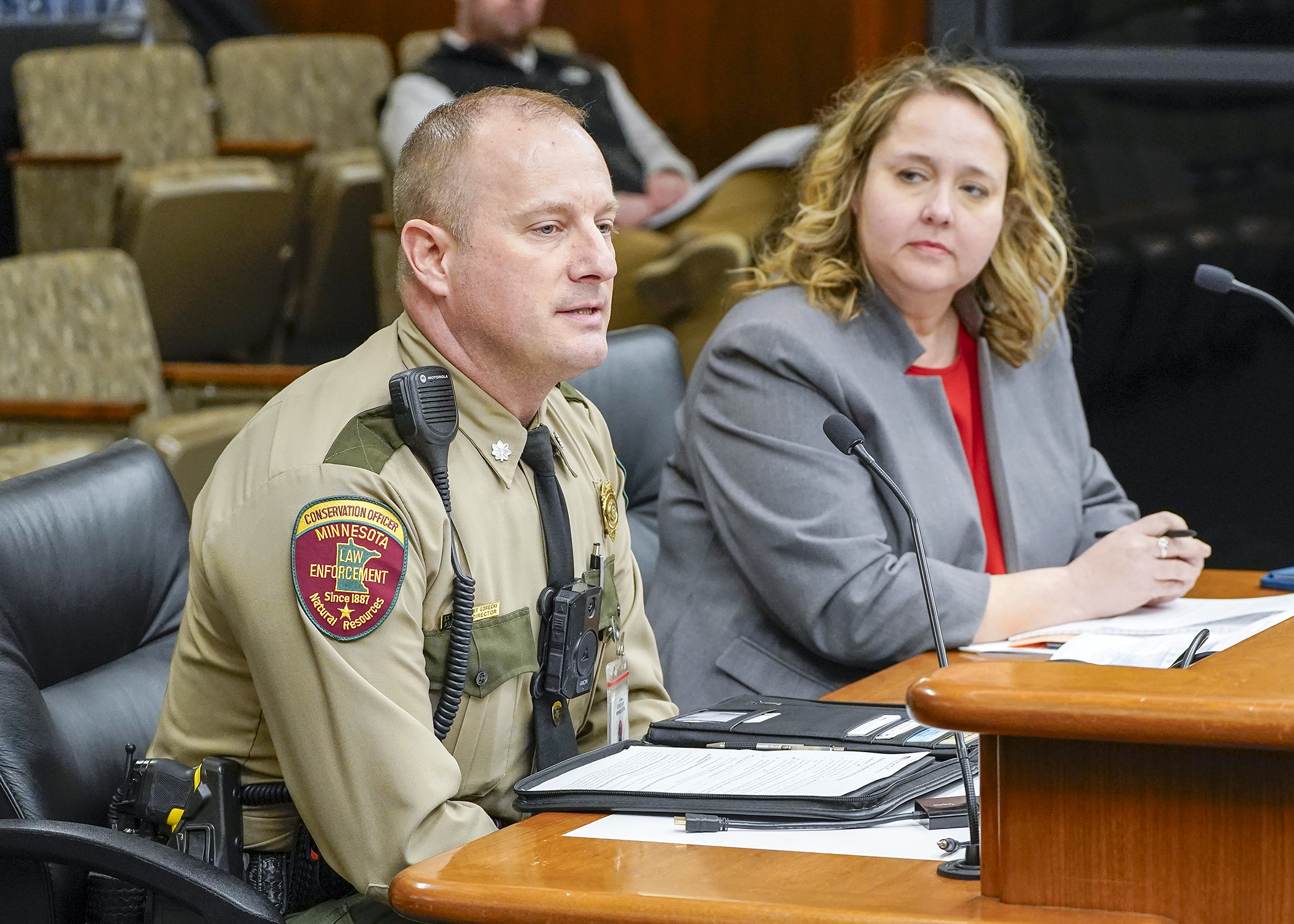 Department of Natural Resources Lt. Col. Robert Gorecki testifies before the House Environment and Natural Resources Finance and Policy Committee in support of HF3376 Rep. Emma Greenman, right, is the bill sponsor. (Photo by Andrew VonBank)